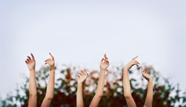 raising hands against clear sky