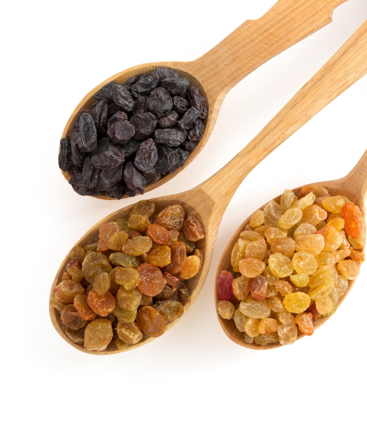 Photo raisins fruit in spoon on white background