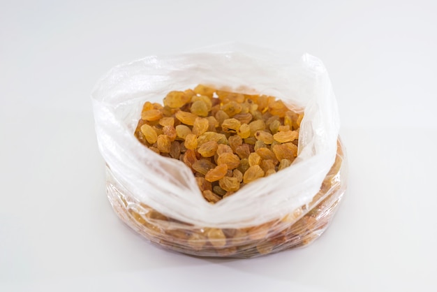 Raisins in a plastic bag on a white background