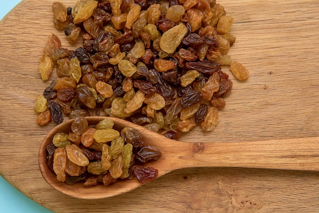 Raisins in a wooden spoon and on a wooden board