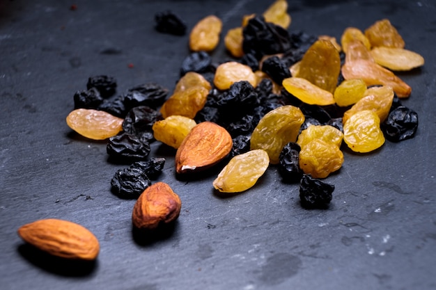 Raisins, yellow, blue, black, golden raisins close-up on a black background. Vega Food, macro foto