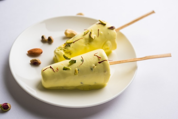 Rajasthani home made ready to eat matka kulfi - saffron or kesariya flavoured with pistachio, cashew and almonds, selective focus