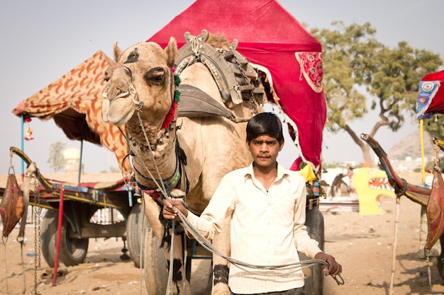 インドのプシュカルで開催されたラクダ フェアでラクダの手綱を握るラージャスターン州の男性