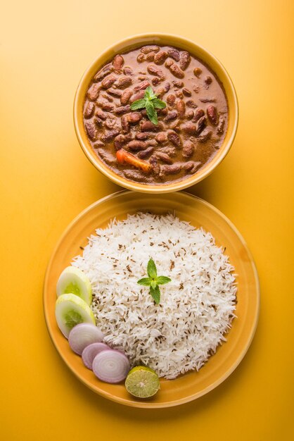 Rajma Or Razma는 향신료와 함께 걸쭉한 육즙에 익힌 붉은 강낭콩으로 구성된 인기 있는 북부 인도 음식입니다. 제라 라이스 & 그린 샐러드와 함께 그릇에 제공