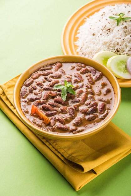 Rajma Or Razma는 향신료와 함께 걸쭉한 육즙에 익힌 붉은 강낭콩으로 구성된 인기 있는 북부 인도 음식입니다. 제라 라이스 & 그린 샐러드와 함께 그릇에 제공