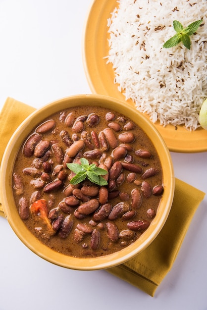 Rajma Or Razma는 향신료와 함께 걸쭉한 육즙에 익힌 붉은 강낭콩으로 구성된 인기 있는 북부 인도 음식입니다. 제라 라이스 & 그린 샐러드와 함께 그릇에 제공