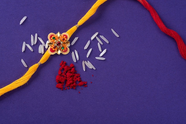 Rakhi met rijstkorrels en kumkum. Een Indiase feestelijke achtergrond