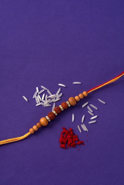 Rakhi with rice grains and kumkum. An Indian festive background