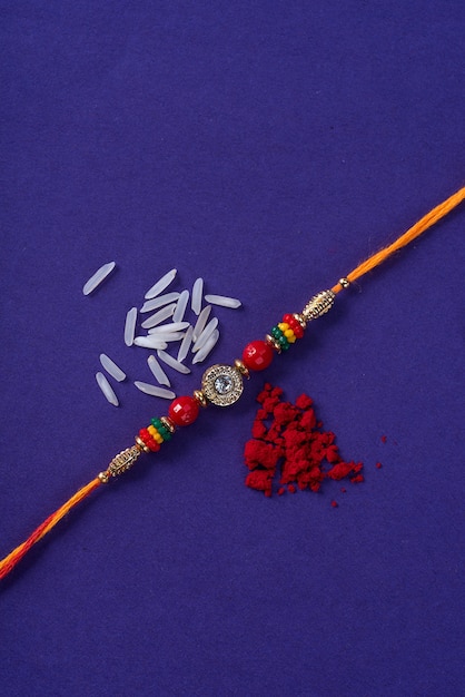 Rakhi with rice grains and kumkum. An Indian festive background