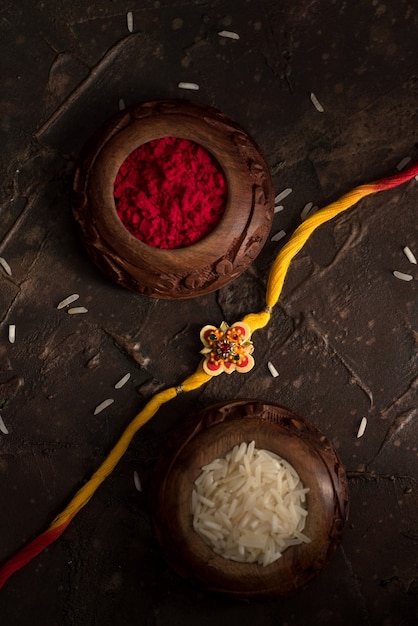 Raksha bandhan-achtergrond met een elegante rakhi, rijstkorrels en kumkum