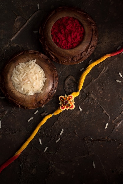 Raksha Bandhan-achtergrond met een elegante Rakhi, rijstkorrels en Kumkum