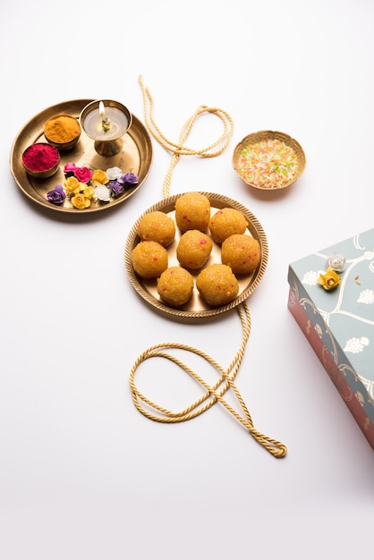 Raksha bandhan Festival : conceptual Rakhi made using plate full of Bundi Laddu sweet with band and Pooja Thali. A traditional Indian wrist band - symbol of love between Brother and Sister