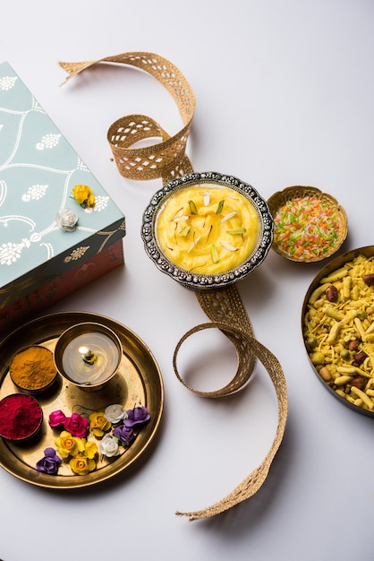 Raksha bandhan Festival: conceptuele Rakhi gemaakt met behulp van Shrikhand in een kom met band en Pooja Thali. Een traditioneel Indiaas polsbandje dat symbool staat voor de liefde tussen broeders en zusters