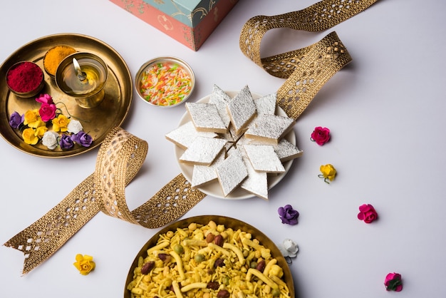 Raksha bandhan Festivalgroeten: conceptuele Rakhi gemaakt met een bord vol Kaju Katli Barfi of Burfi en fancy band en pooja Thali. selectieve focus