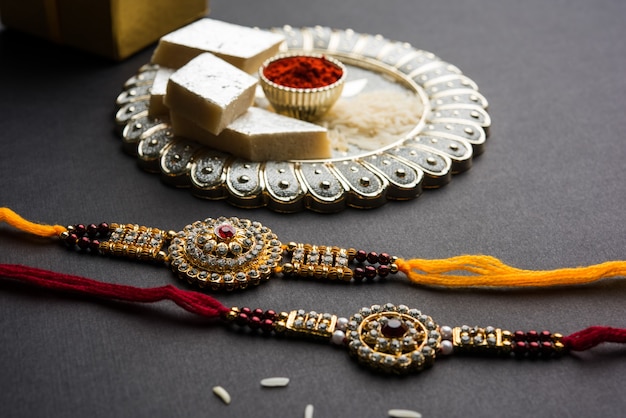 raksha bandhan greeting  rakhi and gift with sweet kaju katli or mithai and rice grains kumkum