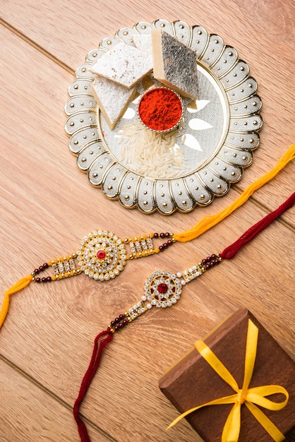 raksha bandhan greeting  rakhi and gift with sweet kaju katli or mithai and rice grains kumkum