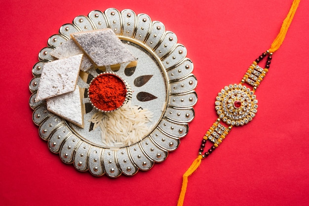 raksha bandhan groet rakhi en cadeau met zoete kaju katli of mithai en rijstkorrels kumkum