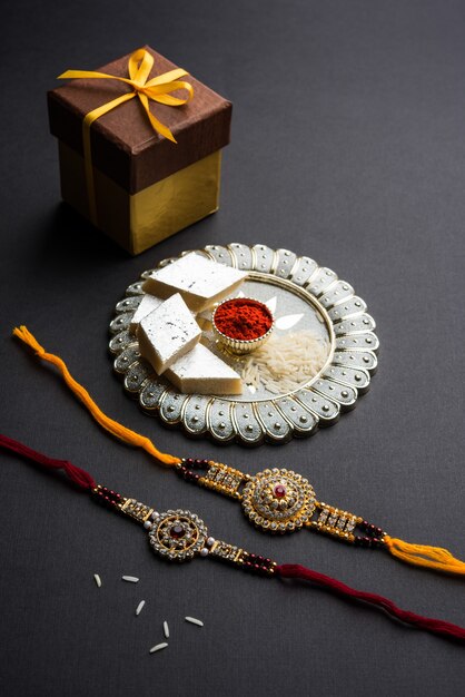 raksha bandhan groet rakhi en cadeau met zoete kaju katli of mithai en rijstkorrels kumkum