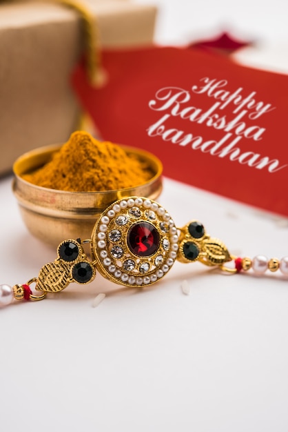 Raksha Bandhan / Rakshabandhan Rakhi with Haldi Kumkum rice, sweet Mithai, Gift Box, selective focus