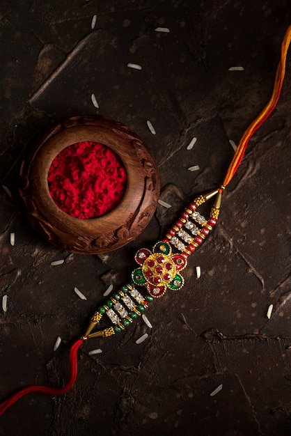 우아한 Rakhi, Rice Grains 및 Kumkum의 Raksha Bandhan. 형제와 자매 사이의 사랑의 상징 인 전통적인 인도 손목 밴드.