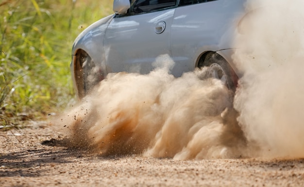 Rally race car drifting on dirt track.