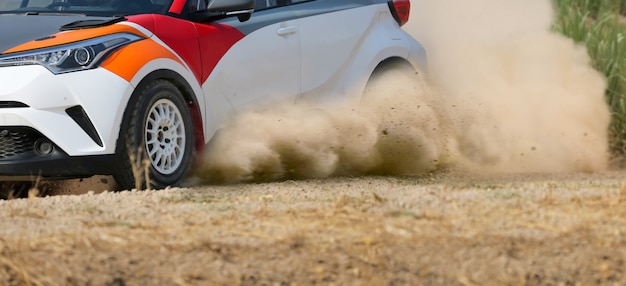 Rallyraceauto die op onverharde weg drijft.