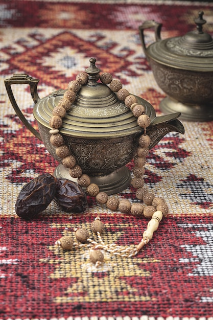 Foto composizione di ramadan con tazza di tè, perline e datteri secchi