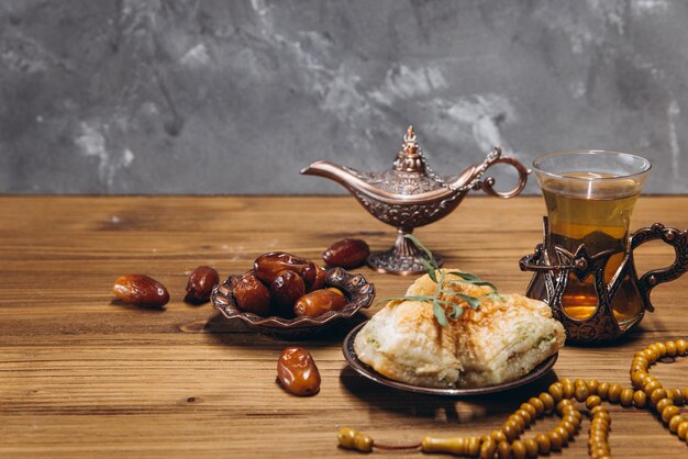 Ramadan concept cup of tea plate of sweet dates and baklava copy space