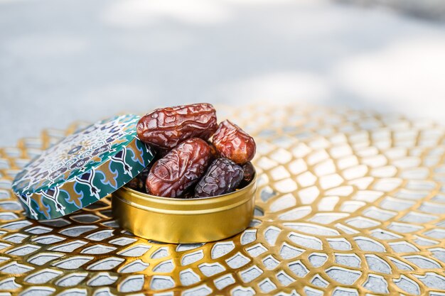 Ramadan concept and some dates in an Islamic pattern container 