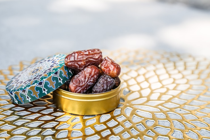 Photo ramadan concept and some dates in an islamic pattern container 