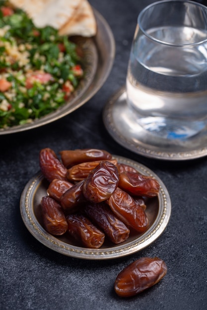 Foto date, acqua e tabboule del ramadan sono cibo tradizionale per iftar nel mondo islamico