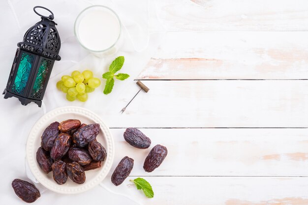 Ramadan food and drinks concept. ramadan lantern with milk, dates fruit