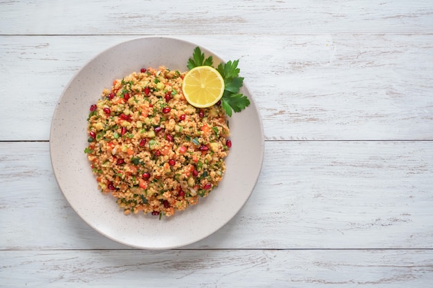 Ramadan food. Salad with couscous and pomegranate background