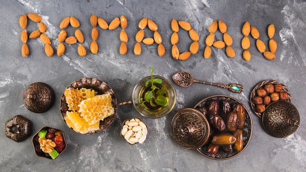 Foto ramadan-inscriptie van amandelen met thee en dadelsfruit