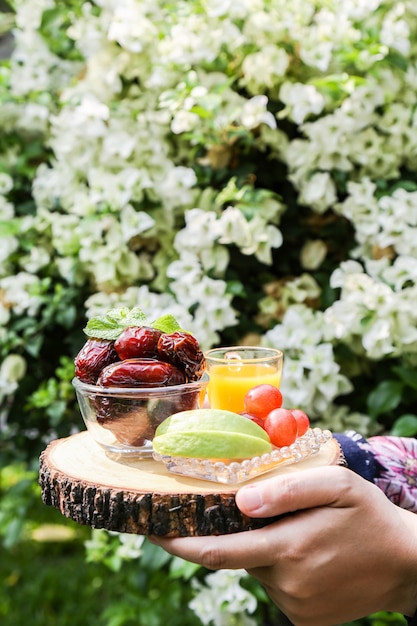 Фото Вдохновение рамадана, показывая много финиковых пальм в миске с набором смешанных фруктов и апельсинового сока