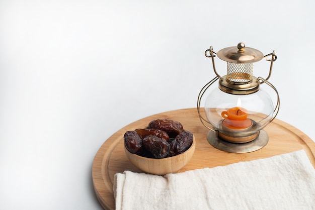 Ramadan Kareem Festival, Dates on wooden bowl with candle lamp