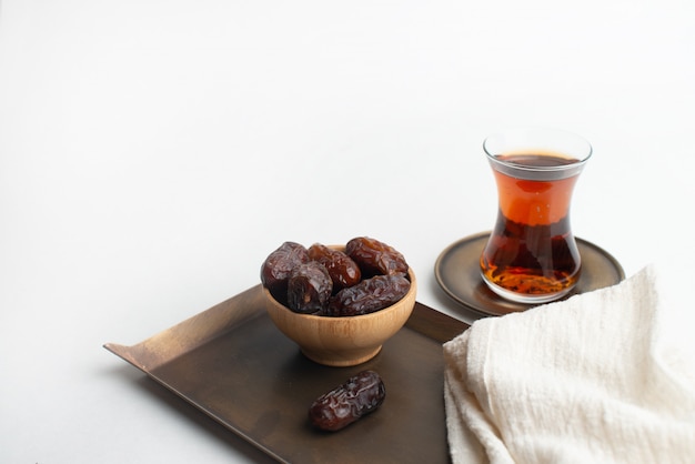 Ramadan Kareem Festival, Dates on wooden bowl with cup of black tea and rosary 