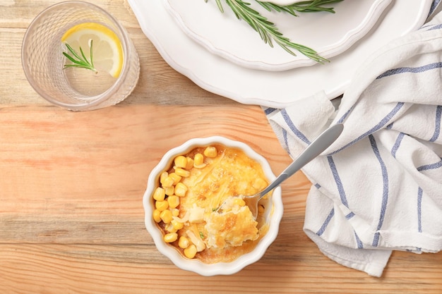 Ramekin and spoon with corn pudding on table