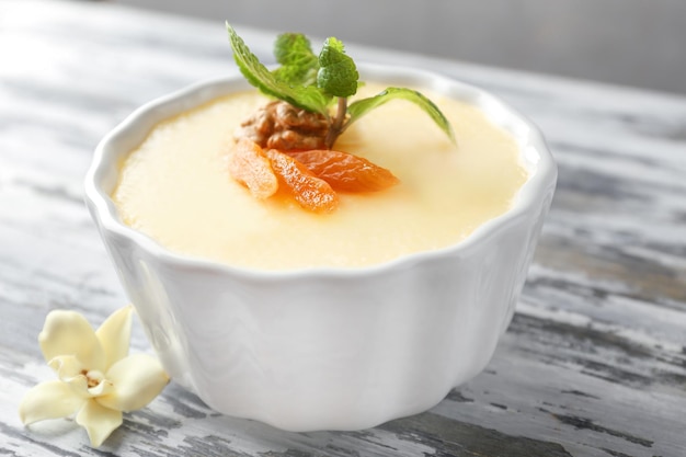 Ramekin with tasty vanilla pudding on table