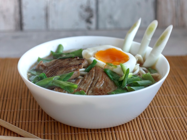 Ramen soup with fresh onions, boiled egg and fried meat