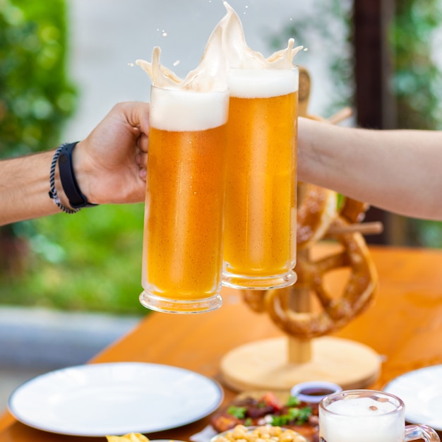 Rammelende bierpullen buiten, snacks op tafel