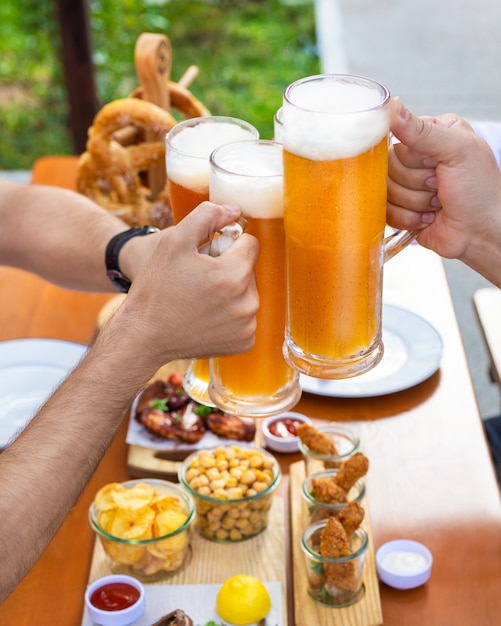 Rammelende bierpullen buiten, snacks op tafel