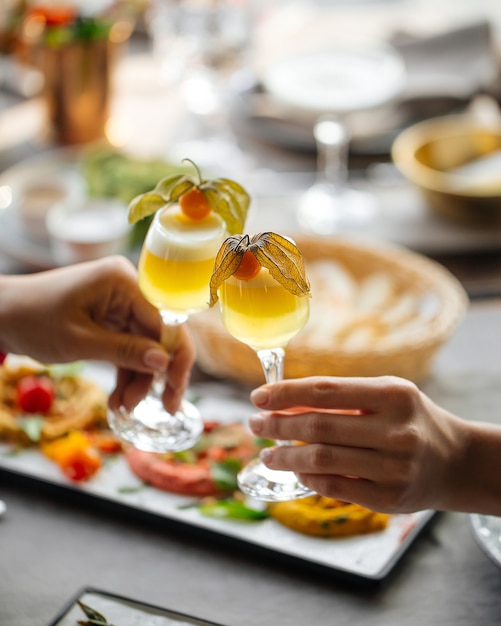 Rammelende borrelglaasjes met zure schuimige cocktails boven de opgediende restauranttafel