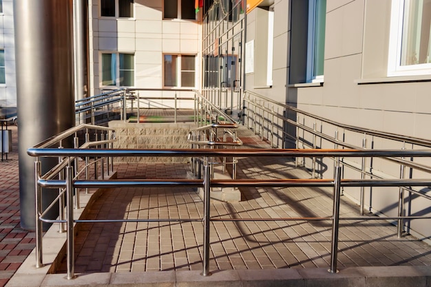 A ramp and metal railings at the entrance to the residential building for the convenience of people with disabilities and the elderly