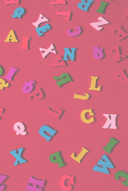 Random colorful alphabet on a red background colorful letters