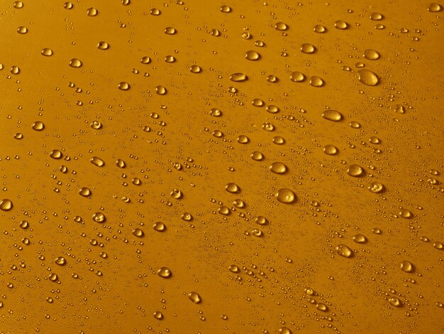 Random water drops on the gold PVC surface