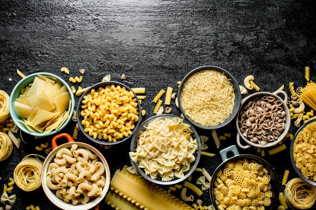 Foto la gamma di diversi tipi di pasta secca in diverse ciotole