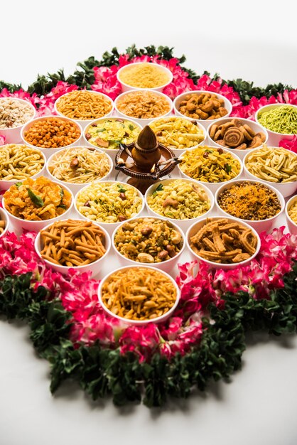 Photo rangoli of farsan or snacks in bowls for diwali with diya