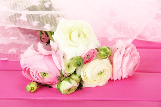 Ranunculus (persian buttercups), on pink wooden  background