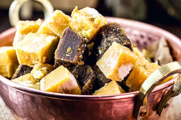 Rapadura candy in pieces inside a copper pot, candy made from sugar cane or molasses from sugar cane